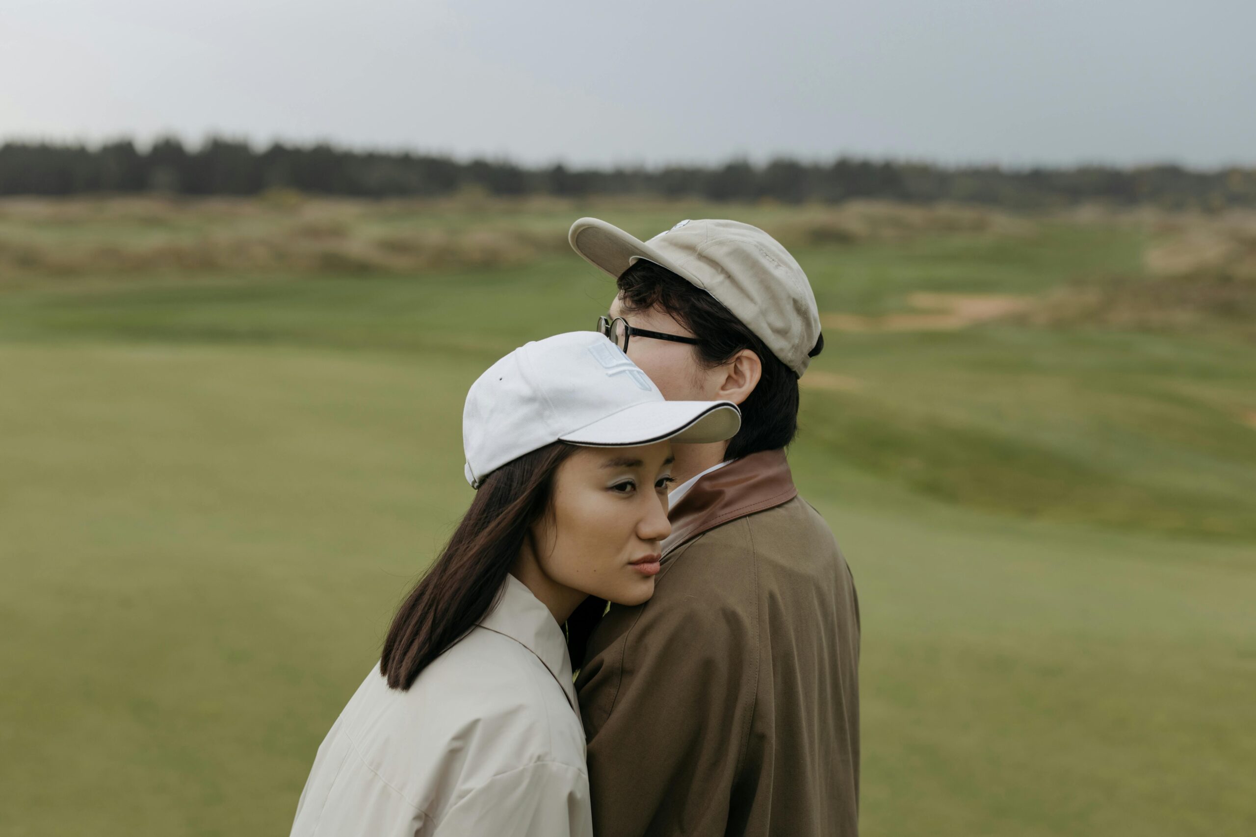 Fashionable golfers in eco-friendly attire standing near a green, embracing modern golf culture.